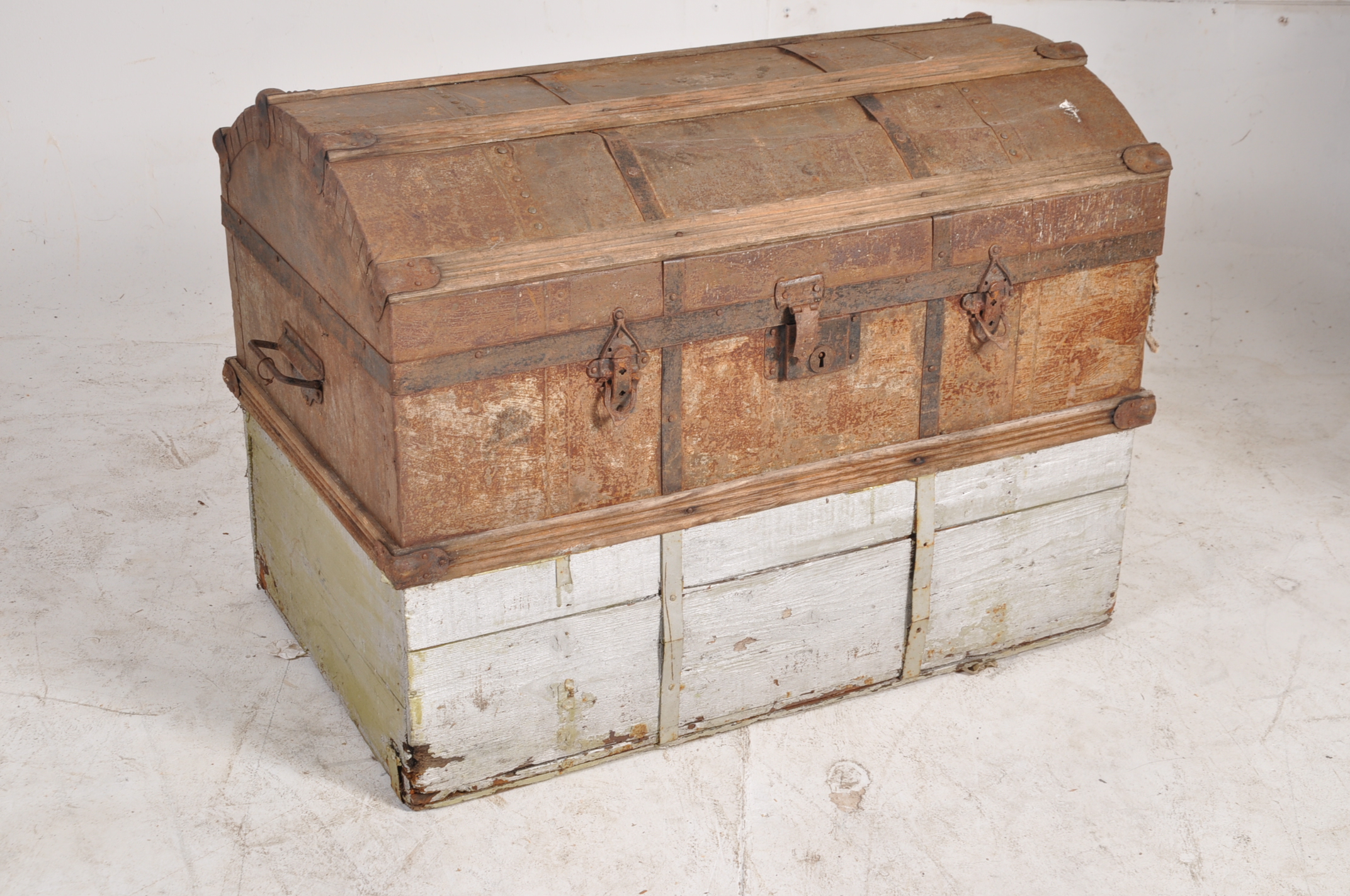 A 19th century metal and wooden bound dome top steamer trunk having carry handles to the sides