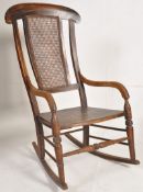 A Victorian mahogany rocking chair with caned back rest, panelled seat and sleigh runners.