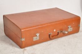 A vintage Revelation all leather travel suitcase with logo to top and matching leather luggage tag
