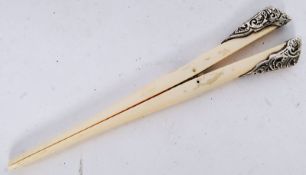 A pair of antique ivory glove stretchers with hallmarked silver hand grips to end.