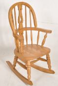 A good quality childs windsor rocking chair constructed of beach wood with arched back and sleigh