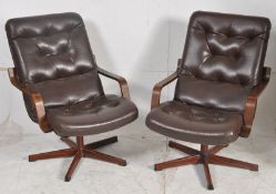 A pair of simulated rosewood and leather swivel armchairs of Danish design. The simulated rosewood