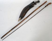 A vintage bamboo sword walking stick cane with white metal banding along with a kukri knife in