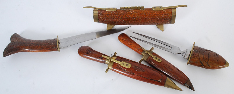 A 20th century wooden carved fish shaped case containing a carving knife and fork to each end.