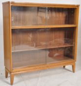 A 1950's retro oak library bookcae cabinet. Tapered legs with sliding glass bookcase cabinet