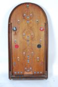 A vintage Corinthium bagatelle board, with colour affixed scoring icons and peg bouncers.