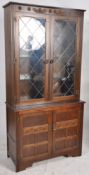 A Jaycee / Old Charm oak display cabinet. The leaded glass cabinet over base beneath. (splits to 2