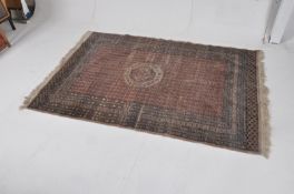 A geometric tassle ended Islamic style carpet of pale form with red centre. 202cms  x 130cms
