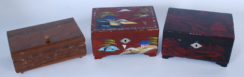 A collection of three boxes, one being carved, the others being lacquered jewellery boxes.