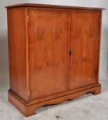 A Regency style yew wood sideboard. Plinth base having upright body with double doors and flared
