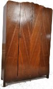 A 1930's Art Deco oak single wardrobe. Raised on rocket shaped atomic feet having an upright body