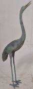 A large painted bronze crane bird garden ornament. Painted grey with later repair to neck.