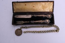 An antique cased silver knife, along with an unmarked white metal silver pickle fork, and a possibly