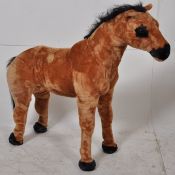 A childs ride on play horse of sturdy construction having fur outer body.