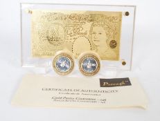 A pure 24ct gold £50 note in an acryllic display case together with two 10 dollar gaming tokens .999