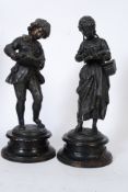 A pair of 19th century continental bronze figurines, boy and girl students in the manner of Moreau