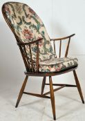 A vintage 20th century Ercol beech and elm windsor armchair. Raised on turned legs united by