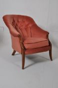 A Victorian style mahogany spoon back armchair raised on slender supports with button backed pink