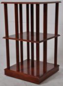 A 20th century mahogany revolving bookcase raised on hidden castors with slatted sides.