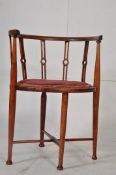 An Edwardian mahogany oval corner chair. Raised on turned legs united by stretchers having velour