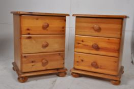 A pair of contemporary pine bedside cabinets raised on bun feet with a bank of 3 drawers to each,