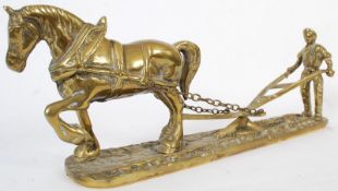 A 20th century study in brass of a farmer and horse drawn plough. 48cm in length.