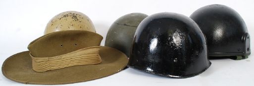 A collection of military helmets to include an original US liner
