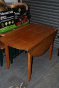 A large retro 1970's oak drop leaf dining table raised on angular tapered legs