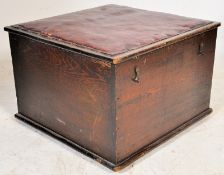 An early 20th century oak blanket box of square form with hinged rexxine upholstered lid