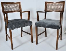 A pair of 1930's bergere armchairs. Raised on square supports having upholstered seats with caned