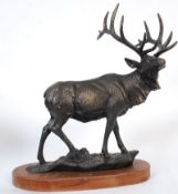 A cast metal decorative statue figurine of a stag on a wooden plinth base. 49cm tall.
