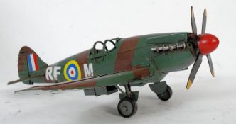 A pressed tin metal model statue of a WWII army spitfire aeroplane.