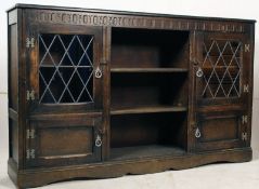 A large  Jacobean revival oak bookcase cabinet having leaded glass doors to the cabinets with open