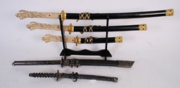 An ' Ancient Warrior ' decorative wall hanging sword, along with another and a graduating set of 3