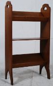 A 1930's solid oak bookcase trough stand. Raised on arched supports with shelves and book troughs to