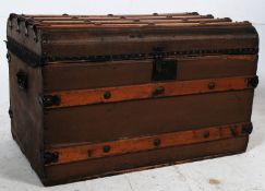 An early 20th century canvas and wooden bound steamer trunk having hinged lid with open storage