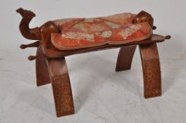 A 20th century hardwood and leather camel stool.