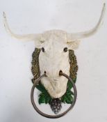 A cast metal bust of a bull with horns and hooped nose, with hand painted decoration. 29cm tall.