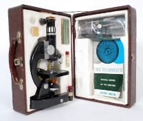 A vintage boxed childs scientific microscope with accessories to include slides, scalpels and