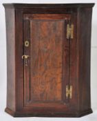 A late 18th century Georgian country oak hanging wall cabinet. Door to front with shelf inside.