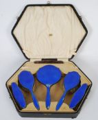 A hallmarked silver dressing table set with striking deep blue enamel colouring, in the original