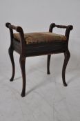 An Edwardian mahogany piano stool. Raised on serpentine legs with handles atop having hinged lid