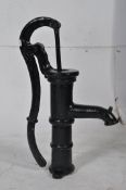 A vintage cast iron ebonised garden water pump with scrolled handle and cylinder shaped body