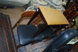 A pair of black seated retro dining chairs and a stool.