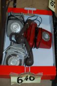 Three retro telephones, two gray and one in red.