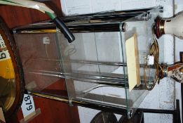 Two modernist style chrome and glass shelving units, being 3 tiers