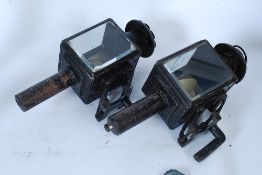 A pair of Edwardian carriage lamps being converted for electricity bearing makers labels for