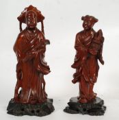 Two carved Chinese oriental figures on ebonised pierced bases.