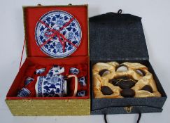 A YiXing boxed clay Chinese oriental tea set in lined case along with another in blue and white