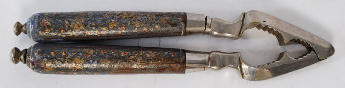 A pair of Victorian hand painted and white metal silver topped nutcrackers.